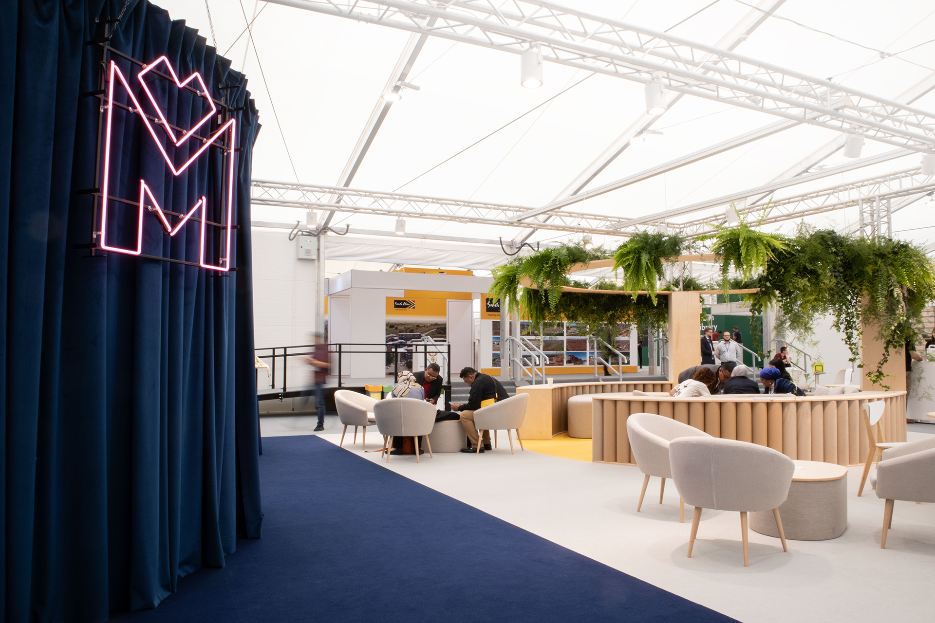Photo of the stand, view of the networking zone, neon with the logotype of the GZM Metropolis