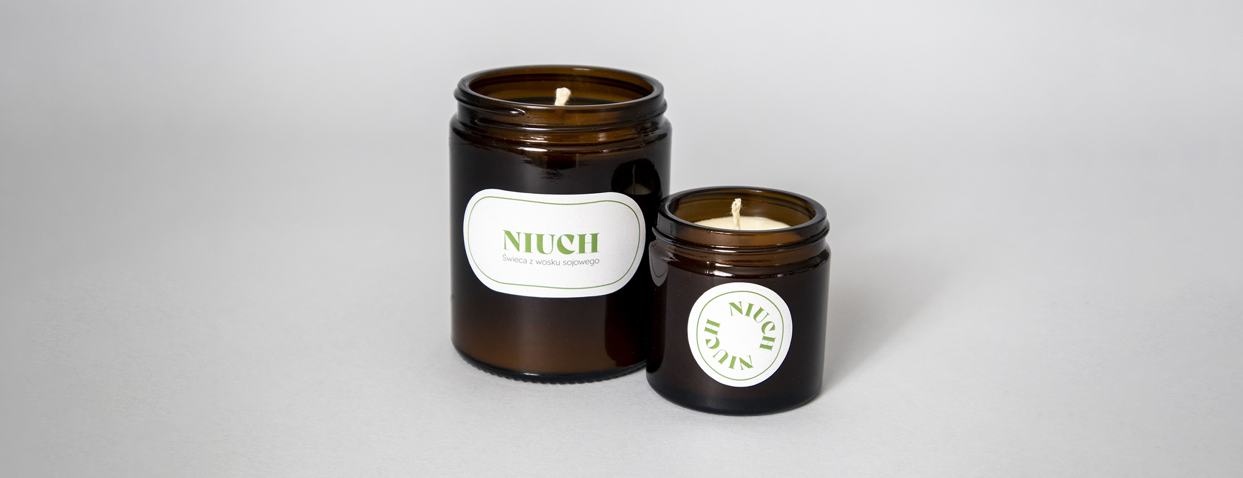 The main photo of the NIUCH project, two dark glass jars with the NIUCH branding