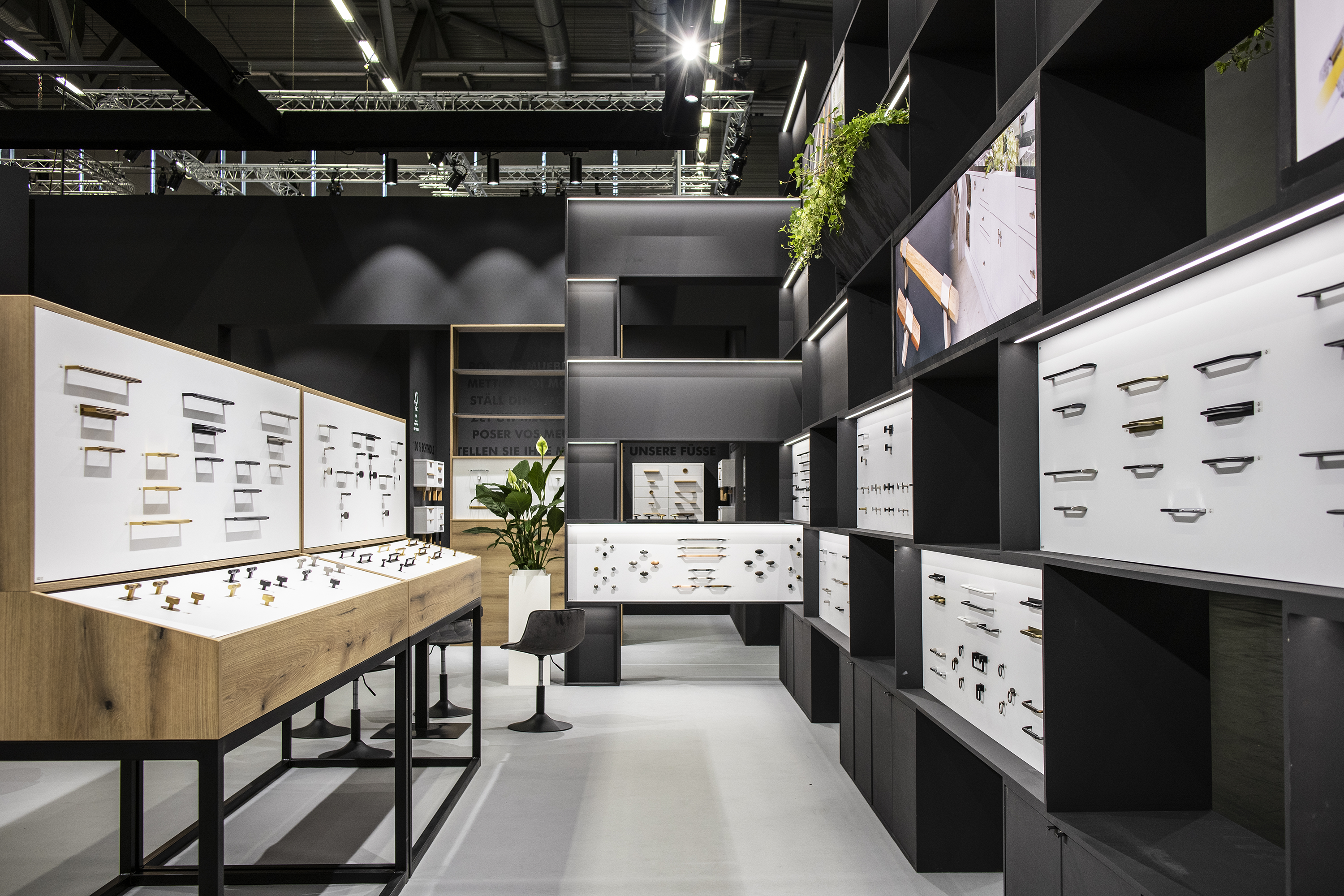 View of the inside of the stand. On the left, a standing display with handles, on the right, a wall with a built-in exhibition.