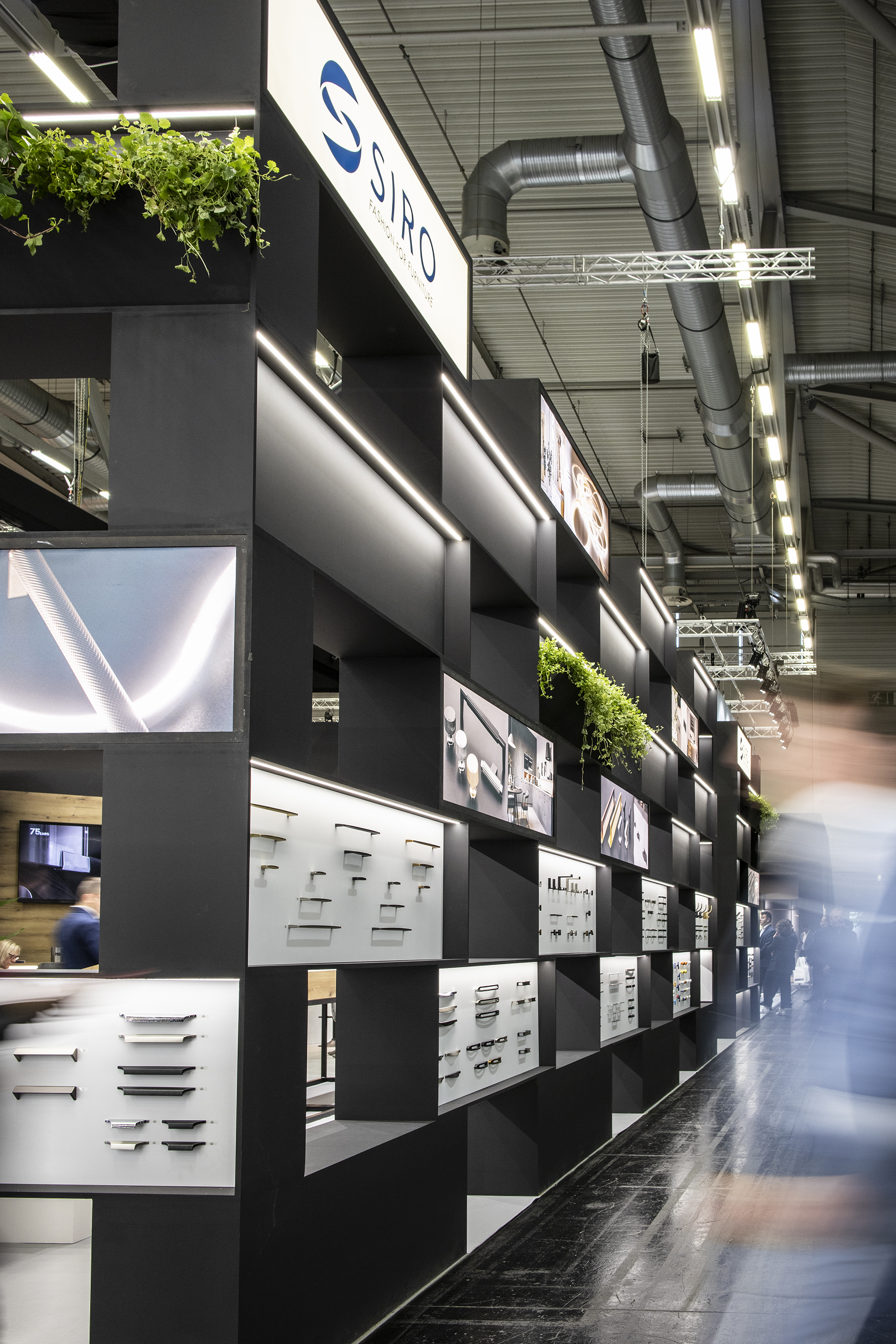 View of the stand from the outside, visible SIRO logotype, blurred silhouette of a visitor to the fair.